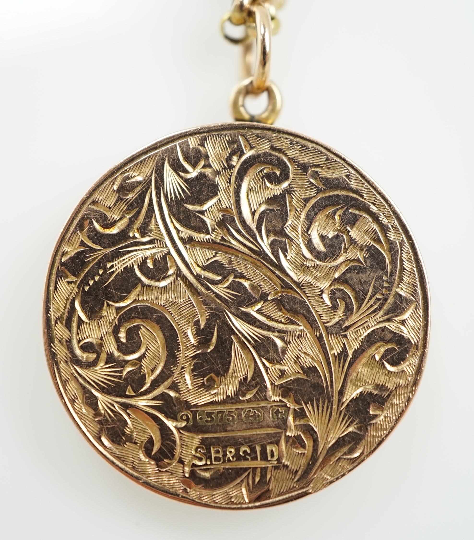 A George V engraved 9ct gold circular locket, diameter 25mm, on a 9ct chain, 45cm